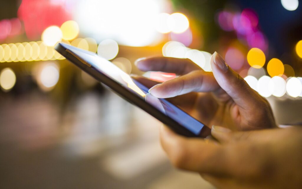 Closeup of a person using a device in public